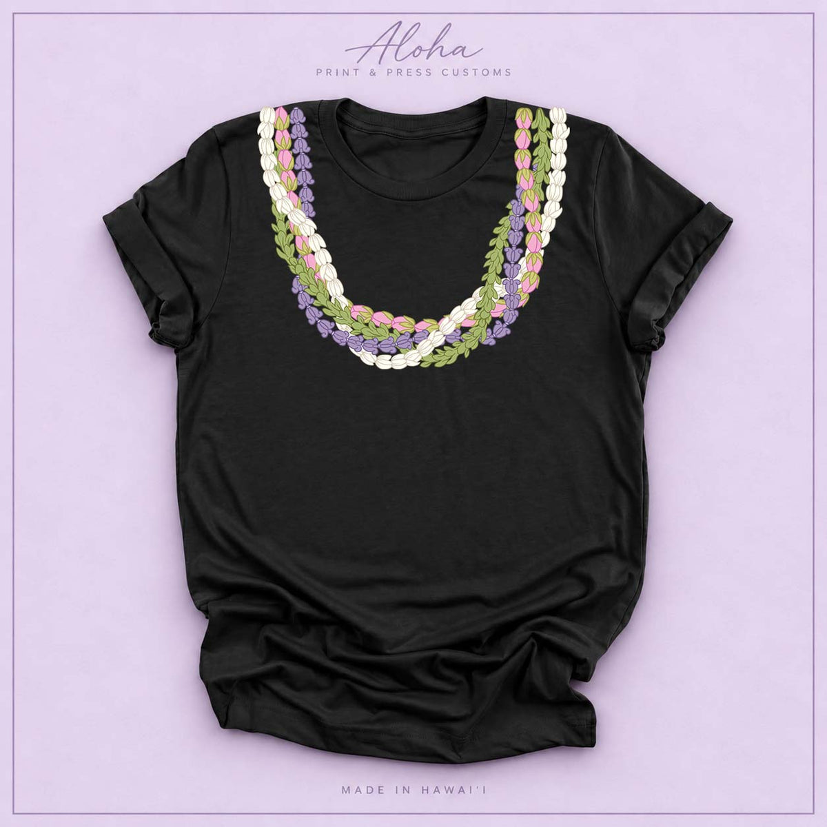 Black T-shirt featuring an island-inspired floral lei design on Aloha Print & Press Customs branded background