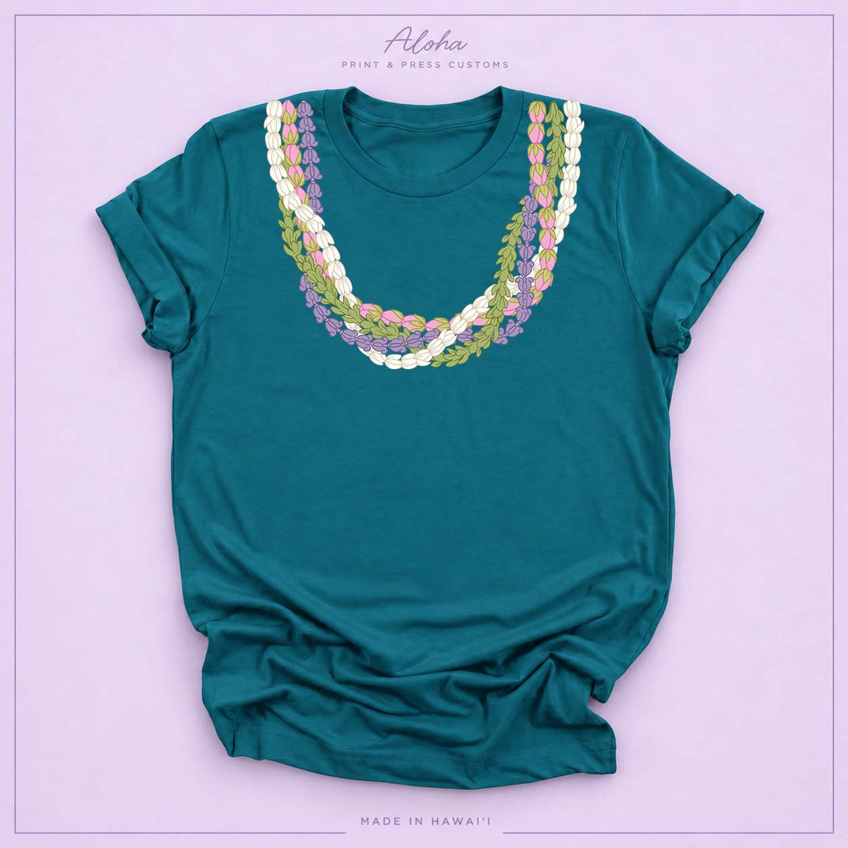 Deep teal T-shirt featuring an island-inspired floral lei design on Aloha Print & Press Customs branded background
