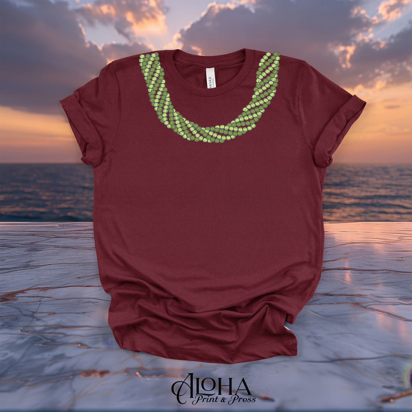 Maroon Mokihana lei T-shirt featuring a bright green Hawaiian lei neckline design on a sunset beach background