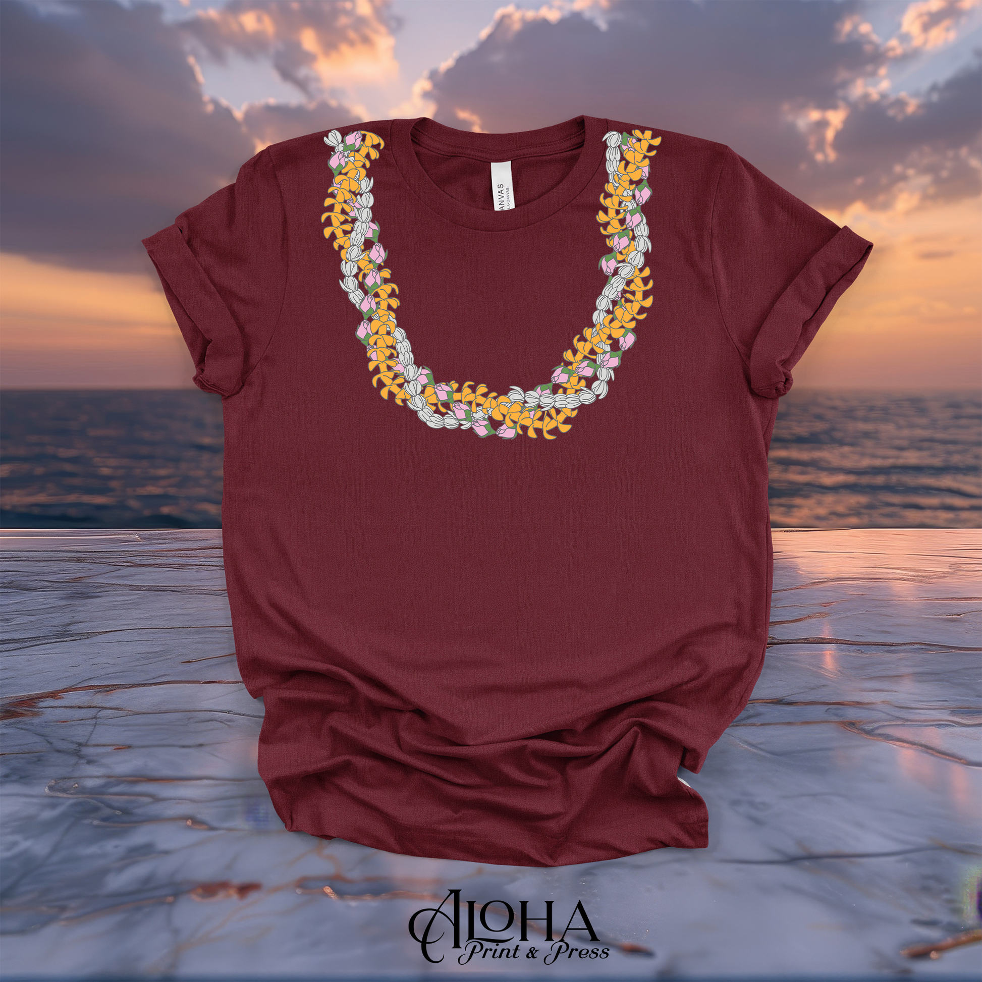 Maroon red t-shirt printed with traditional layered Hawaiian lei flowers around the neckline.