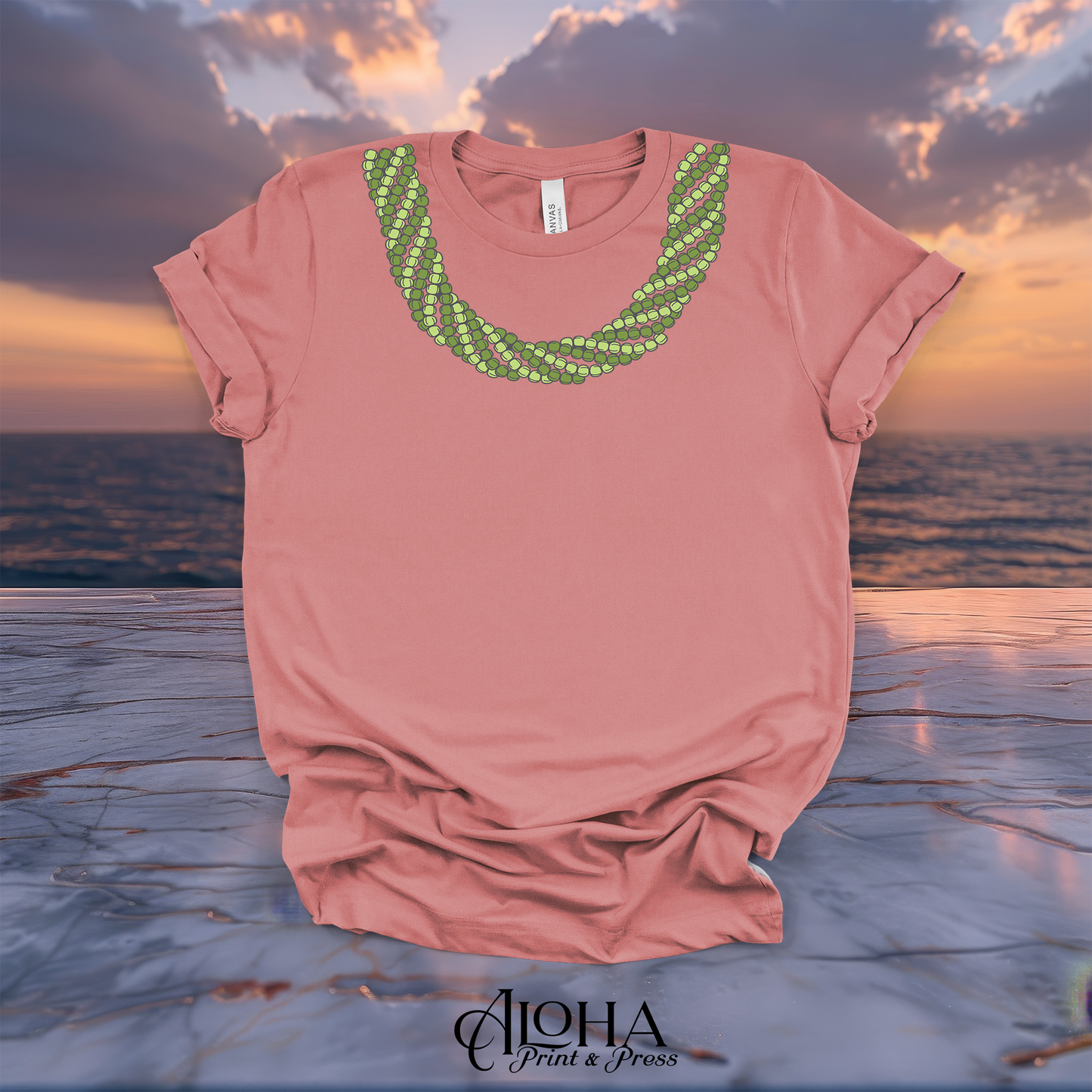 Mauve Mokihana lei graphic tee with a layered green lei design displayed against a Hawaiian sunset background
