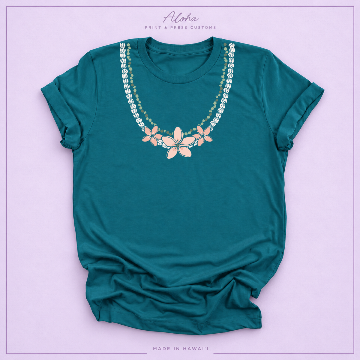 Deep teal T-shirt with Pikake Mokihana Plumeria Hawaiian lei necklace design on Aloha Print & Press Customs branded background