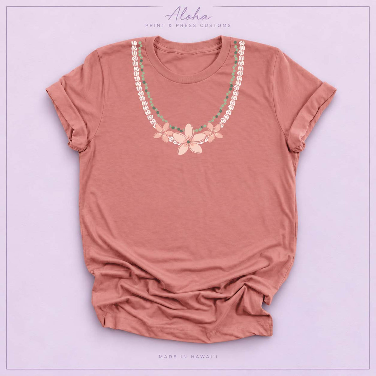 Mauve T-shirt with Pikake Mokihana Plumeria Hawaiian lei necklace design on Aloha Print & Press Customs branded background