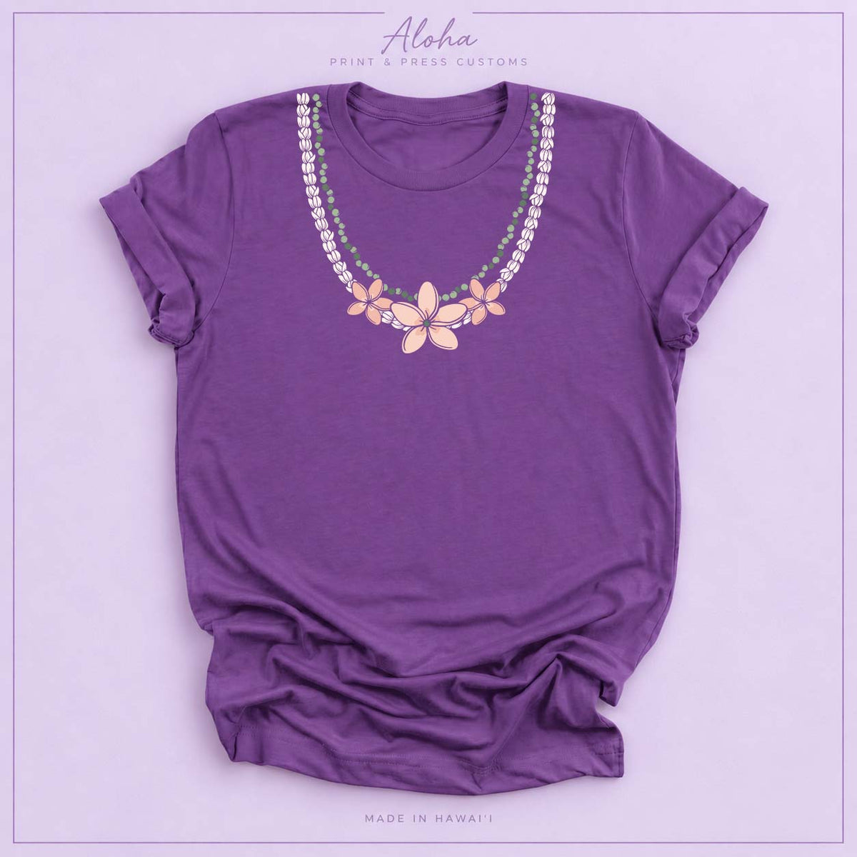 Purple T-shirt with Pikake Mokihana Plumeria Hawaiian lei necklace design on Aloha Print & Press Customs branded background