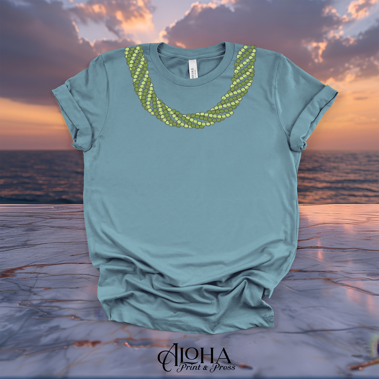 Vintage denim blue Mokihana lei T-shirt with a green Hawaiian lei neckline design on a sunset background